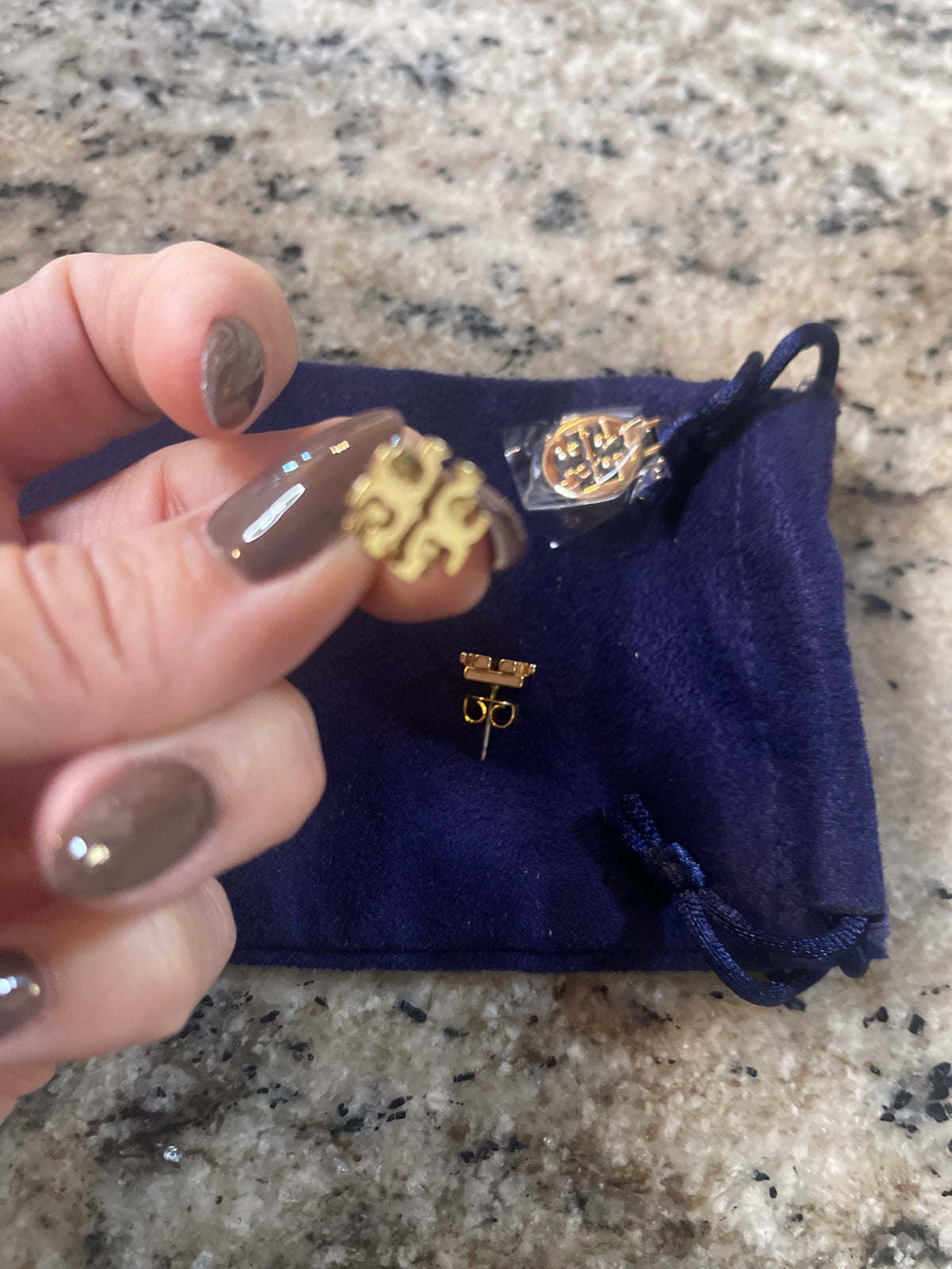 Tory Burch Goldtone stud earrings featuring signature Double T logo.