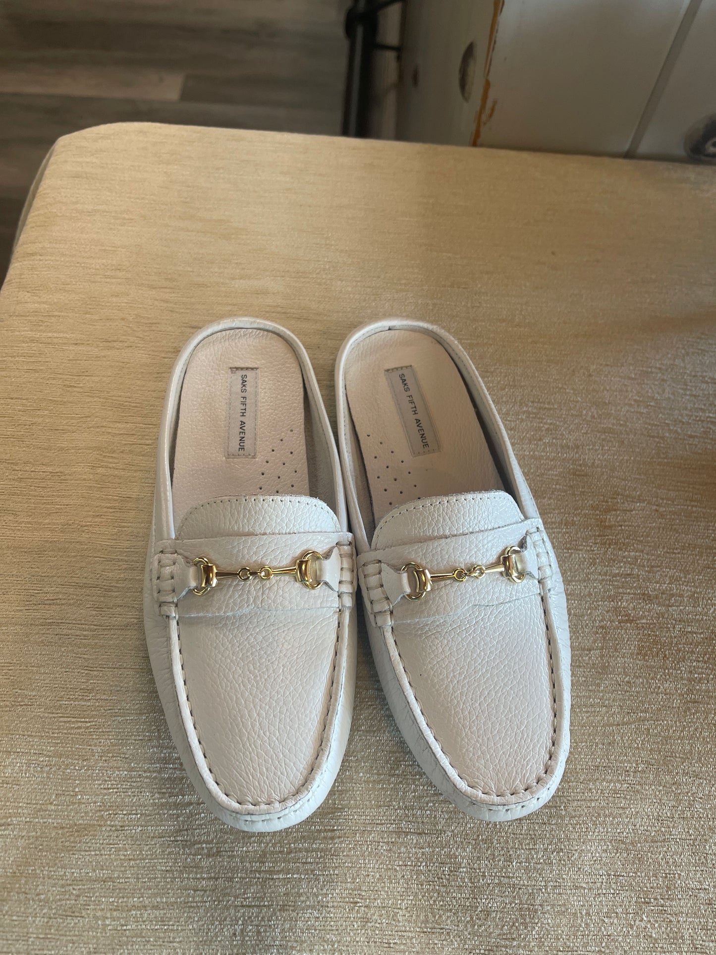 These Saks Fifth Avenue slip-on leather loafers feature a prominent gold-tone horsebit accent