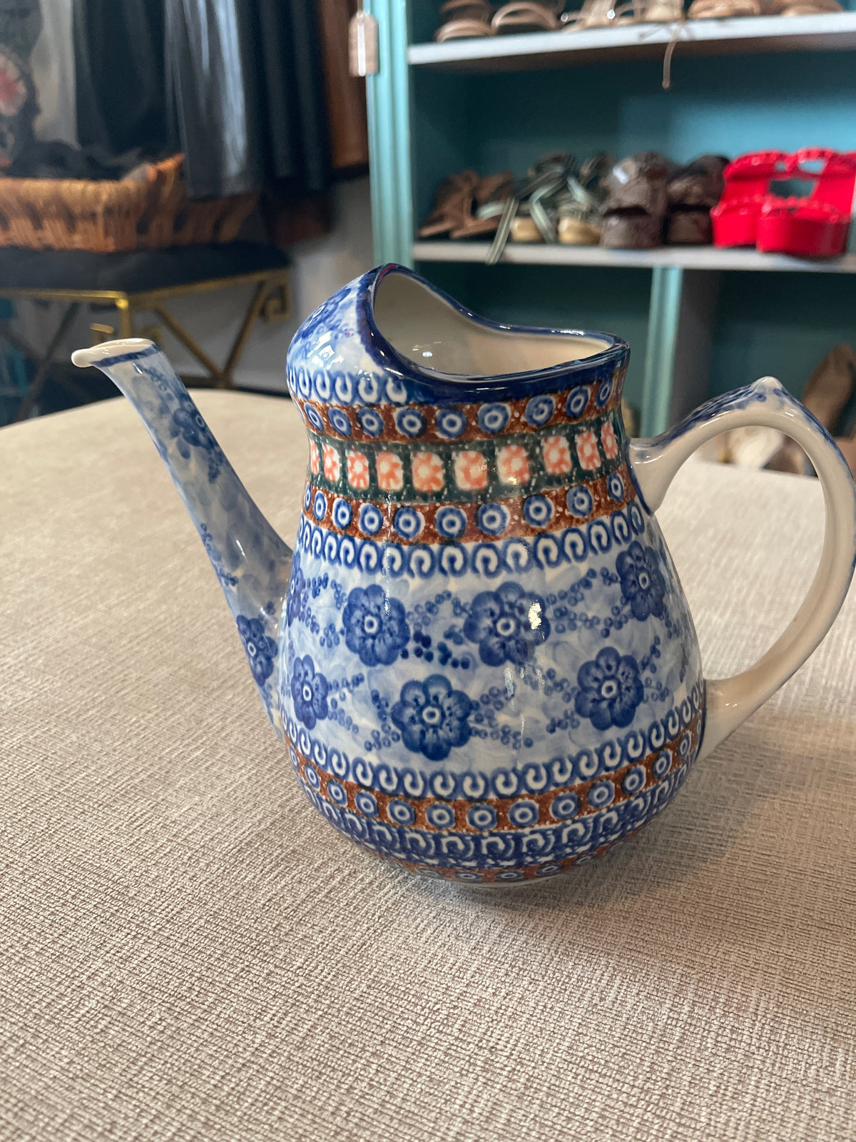 This is a Polish Pottery Unikat watering can pitcher in the "Dancing Blue Poppies" (U57A) pattern, measuring approximately 8.25 inches tall with a 71-ounce capacit