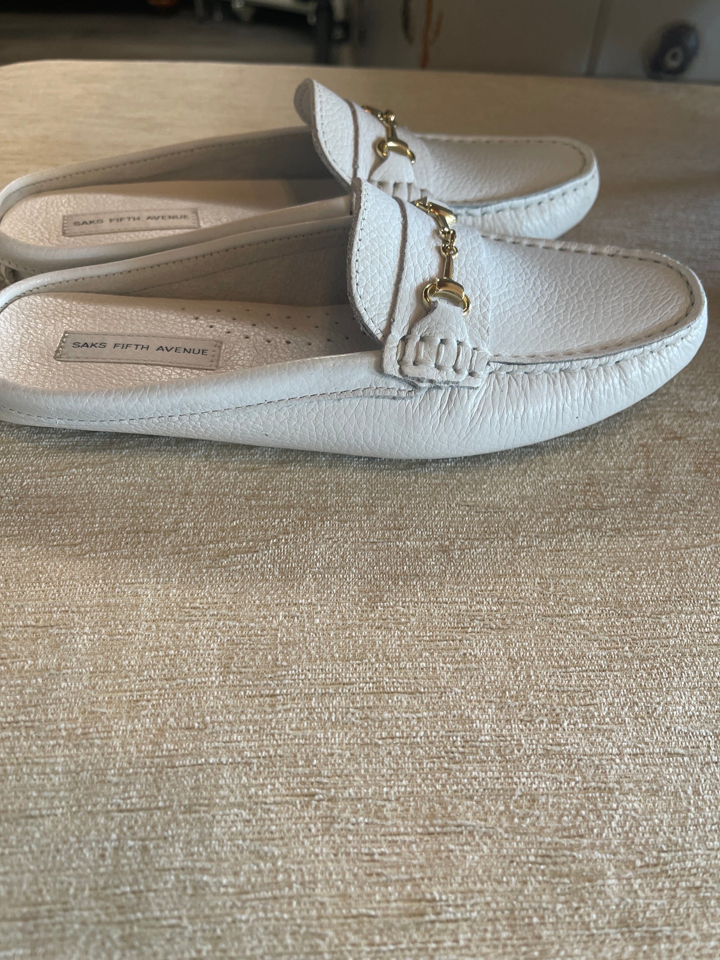 These Saks Fifth Avenue slip-on leather loafers feature a prominent gold-tone horsebit accent